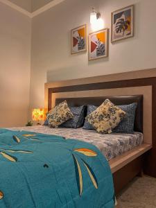 sypialnia z łóżkiem z niebieską kołdrą i poduszkami w obiekcie Arzu Homes w mieście Anjuna
