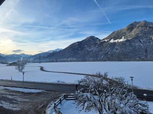 a snowy road next to a lake with mountains at Zillerbruggerhof in Bruck am Ziller