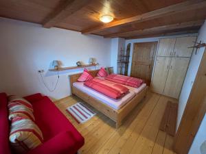 a room with a bed with red pillows on it at Zillerbruggerhof in Bruck am Ziller