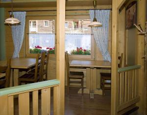 a dining room with a table and chairs and windows at La Locanda in Livigno