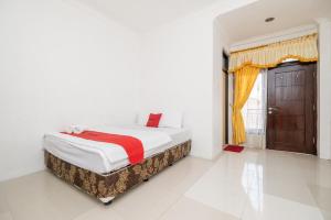 een slaapkamer met een bed en een raam bij Grha Rahadi 2 Wiyung RedPartner in Surabaya