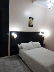 a bedroom with a large white bed with two pillows at HOTEL IKRAM ORAN in Oran