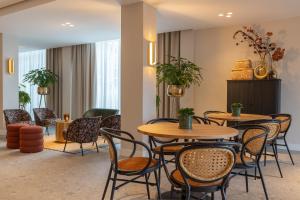 Van der Valk hotel Den Haag Wassenaar في فاسينار: مطعم بطاولتين وكراسي ونباتات