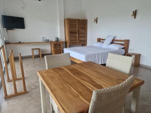 ein Schlafzimmer mit einem Bett sowie einem Holztisch und Stühlen in der Unterkunft Samalanka Boutique Hotel in Habaraduwa Central