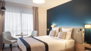a hotel room with a bed and a table at Residhome Sénart in Lieusaint +4 photos