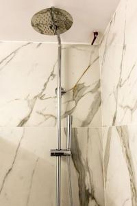 a shower in a bathroom with marble walls at The Golden home 1 in Piraeus