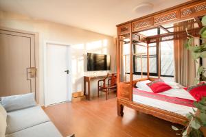 um quarto com uma cama de dossel em madeira e uma secretária em Beijing Rong Courtyard Boutique Hotel em Pequim