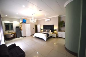 プレトリアにあるBuffels Place Guesthouseの部屋にベッドとソファがある寝室