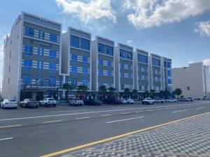 a large building with cars parked in front of it at خيالى2 in Khamis Mushayt