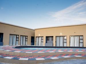 a building with a pool in front of it at AKEMS MOTEL in Kempton Park
