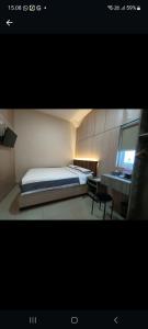 um quarto com uma cama, uma secretária e uma janela em J&L Inn Semarang em Semarang
