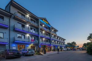 a building with cars parked in front of it at Hotel Sun in Senec