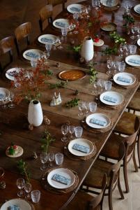 una larga mesa de madera con platos y vasos. en CASAMAAS en Les Basses Masures
