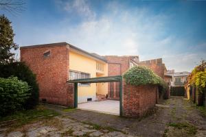 a brick house with a glass door in a yard at Accomodo MIT39 Trivano San Siro in Milan