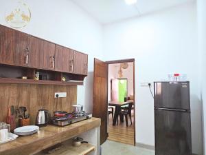 uma cozinha com um frigorífico preto e uma mesa em Galle Face Terrace Hostel by Tourlux em Colombo