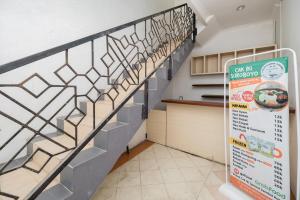 - un escalier dans une cuisine avec un panneau à côté dans l'établissement RedDoorz Plus @ Gunungsari Surabaya, à Kedurus