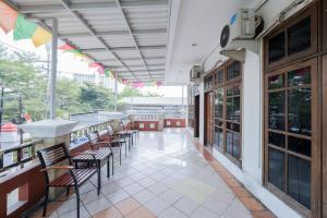 een patio met stoelen en tafels in een gebouw bij RedDoorz Plus @ Gunungsari Surabaya in Kedurus