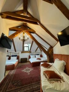 a attic room with two beds and a chandelier at Conacul Dima Predeal in Predeal