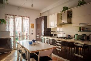 米蘭的住宿－Accomodo MIT39 Trivano San Siro，一间带桌椅的厨房和一间带炉灶的厨房