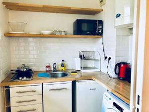 a kitchen with a sink and a microwave at Le Gentil Paris in Gentilly