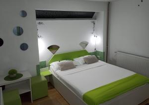 ein grün-weißes Schlafzimmer mit einem Bett und einem Schreibtisch in der Unterkunft Pensiunea Verde in Baia Sprie + 124 Fotos