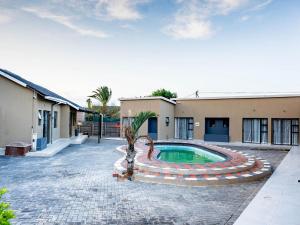 a courtyard with a swimming pool in front of a building at AKEMS MOTEL in Kempton Park