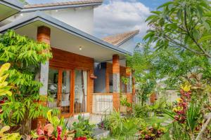 a house with a garden in front of it at Bhavana Cottage in Nusa Penida