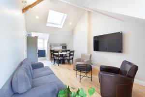 a living room with a blue couch and a tv at Les appartements de Chantilly - gare in Chantilly