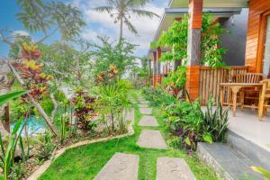 a garden with a pathway leading to a house at Bhavana Cottage in Nusa Penida