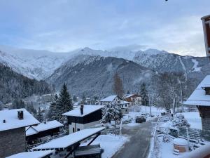 a snow covered village with mountains in the background at DALANIA MOUNTAIN APARTMENTS in Ponte di Legno
