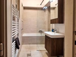 Modern Parkside Garden View Apartment في بودابست: حمام مع حوض ودش