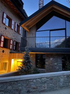 a house with a balcony on top of it at DALANIA MOUNTAIN APARTMENTS in Ponte di Legno