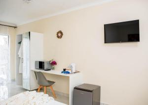 a room with a desk and a tv on a wall at AKEMS MOTEL in Kempton Park