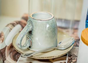 um copo num prato com uma colher numa mesa em AKEMS MOTEL em Kempton Park