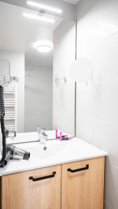 a bathroom with a sink and a mirror at Residhome Sénart in Lieusaint