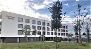 a large white building with trees in front of it at Residhome Sénart in Lieusaint