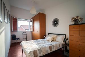 a bedroom with a bed and a dresser and a window at Accomodo MIT39 Trivano San Siro in Milan