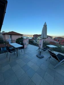 d'une terrasse avec des tables, des chaises et un parasol. dans l'établissement CASA MEDUSA, à La Spezia