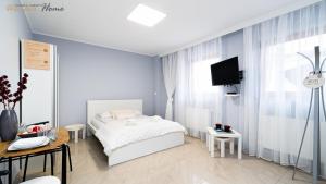 a bedroom with a bed and a tv in it at Wonder Home - Apartamenty w przyziemiu - cicha okolica in Karpacz