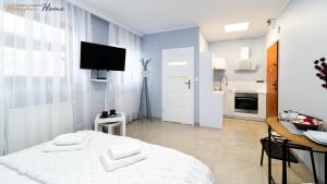a white room with a bed and a kitchen at Wonder Home - Apartamenty w przyziemiu z widokiem na Śnieżkę - cicha okolica in Karpacz