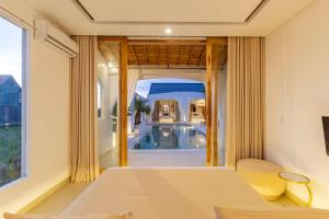 a bedroom with a bed and a view of a pool at CODYARD LUXURY SUITES, close to Seseh Beach in Munggu +128 photos