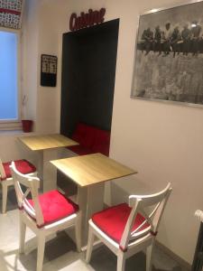 duas mesas e cadeiras com assentos vermelhos num quarto em THE FIRST em Trieste
