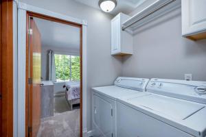 uma lavandaria branca com máquina de lavar e secar roupa em SAFARI VILLA: Luxurious private villa w grand deck em Snohomish