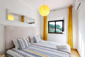 a bedroom with a bed with yellow curtains and a window at Sublime Sun and Van, By Meco Stays in Alfarim