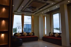uma sala de estar com sofás em frente às janelas em GOLDEN GLEAM RESORTS em Ingrāj Bāzār