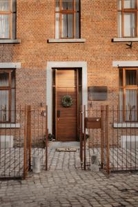 a brick building with a wooden door in front at Huize Schaberg in Borgloon