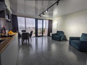 eine Küche und ein Wohnzimmer mit einem Tisch und Stühlen in der Unterkunft Tirkius House in Kobuleti