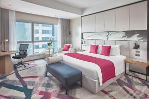 ein Hotelzimmer mit einem großen Bett und einem Schreibtisch in der Unterkunft Crowne Plaza Manila Galleria, an IHG Hotel in Manila