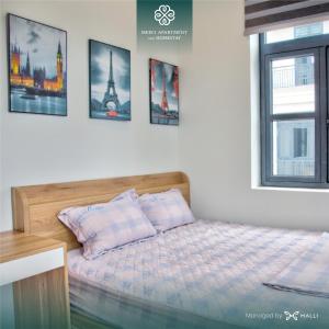Chuỗi căn hộ Merci Apartment & Homestay - Vinhomes Imperia Hai Phong في هاي فونج: غرفة نوم بسرير وصور على الحائط