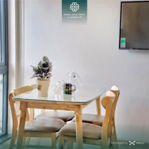 Chuỗi căn hộ Merci Apartment & Homestay - Vinhomes Imperia Hai Phong في هاي فونج: طاولة وكرسيين عليها زرع